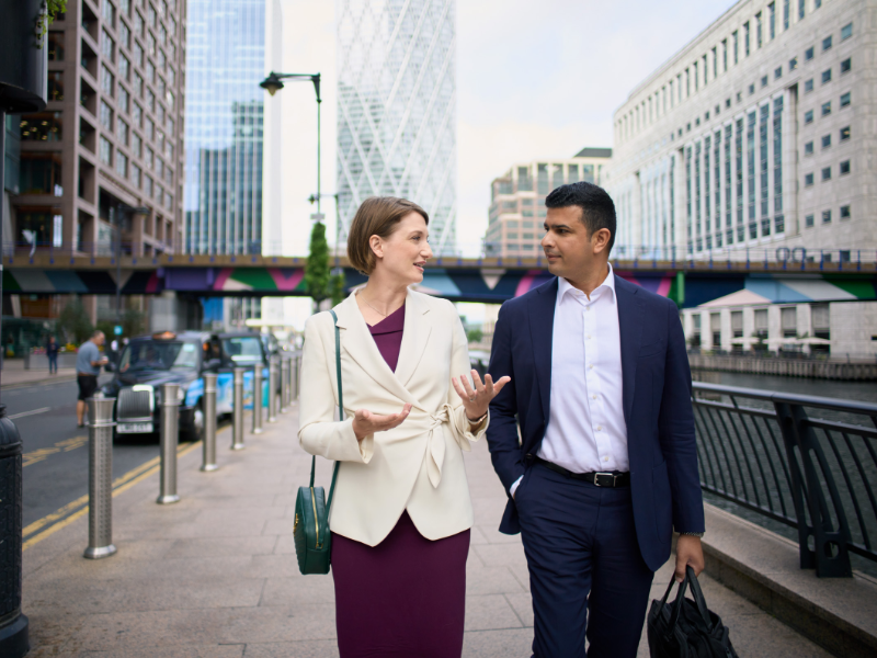 Two people on the streets of London talking about business